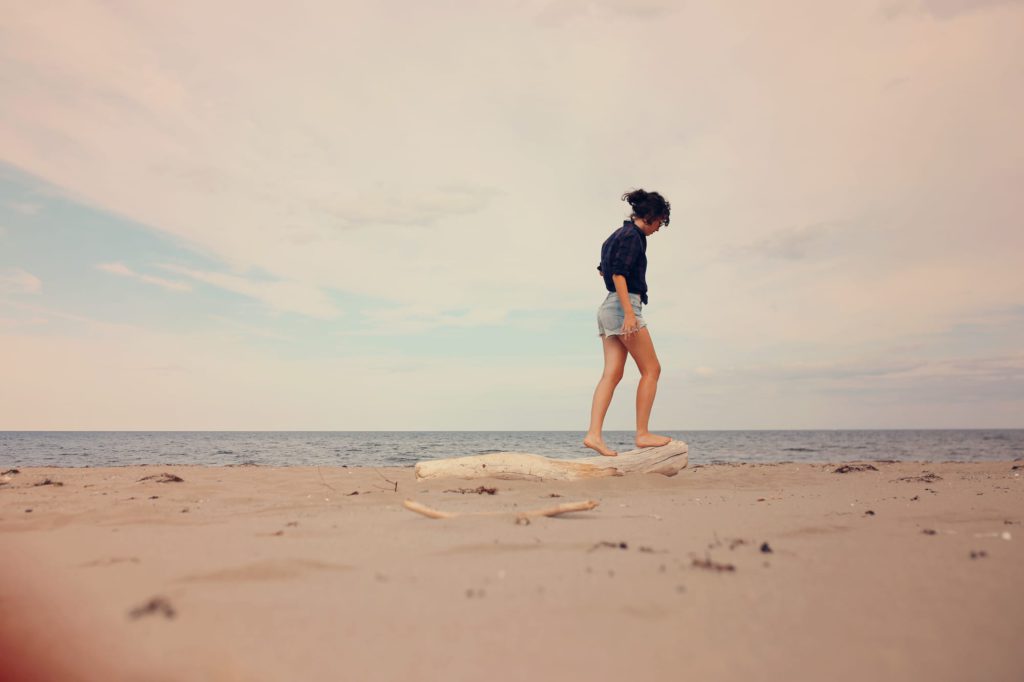 woman walking barefoot on sand