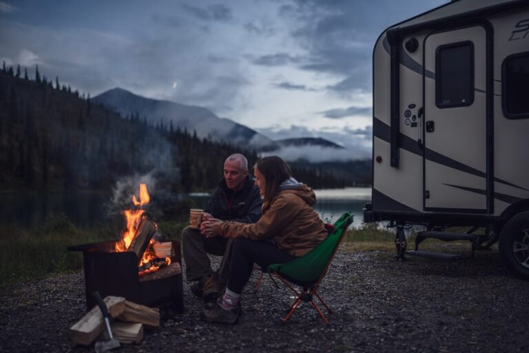 couple by the campfire and their RV