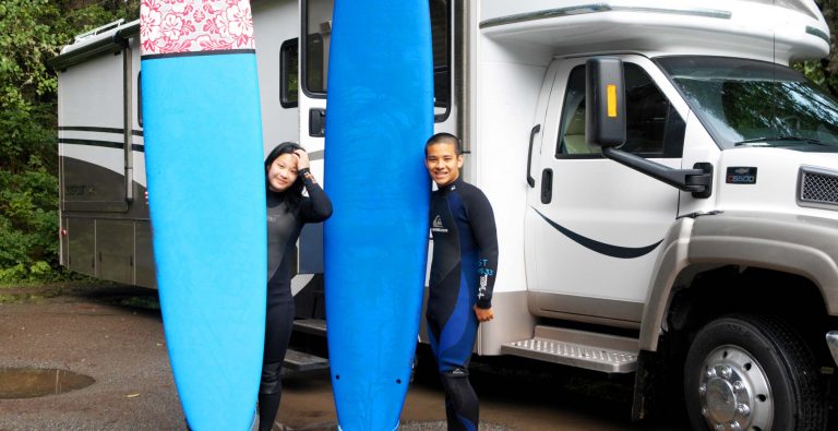 Kids with surfboards in front of an rv