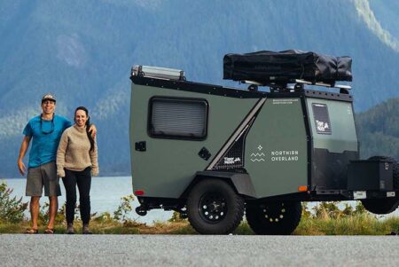 COUPLE BY A TRAVEL TRAILER