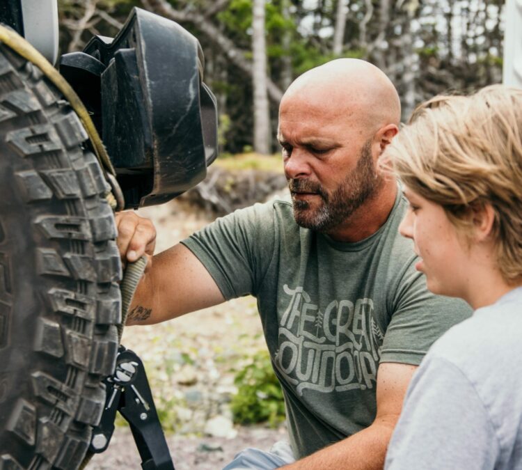 Bryan Baeumler with son hitching Jeep to RV
