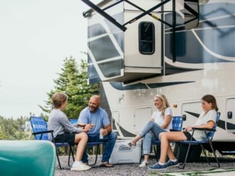 Bryan Baeumler and family sitting in front of their RV