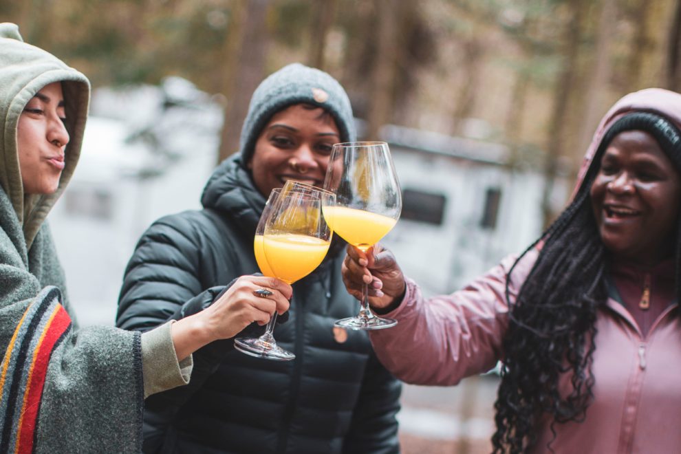three women from BGOW drinking mimosas while camping in Quebec in their RV