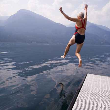 Woman jumping off of a dock into the water