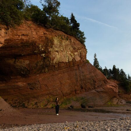 Woman standing at the edge of the St Martins Sea Caves