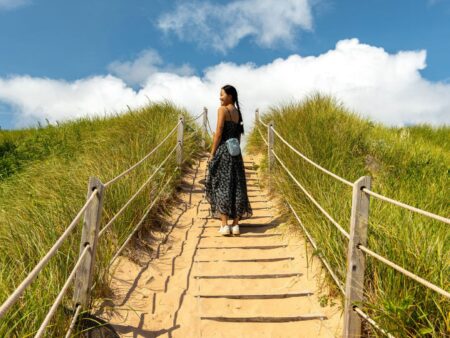 Woman walking up a sand dune