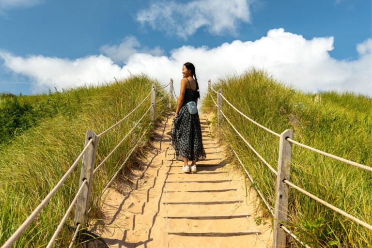 Woman walking up a sand dune