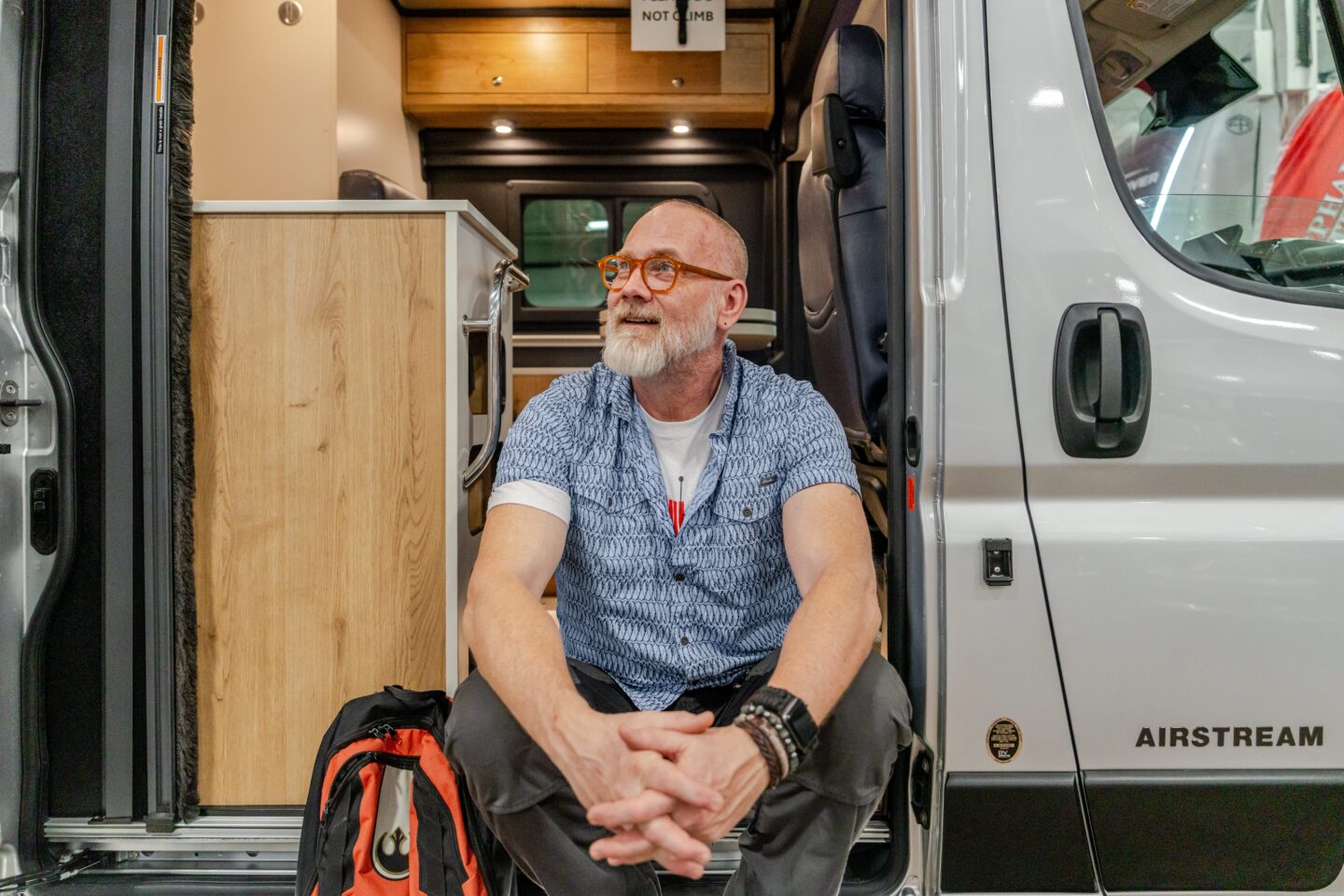 Man sitting at the entrance of his Class B motorhome