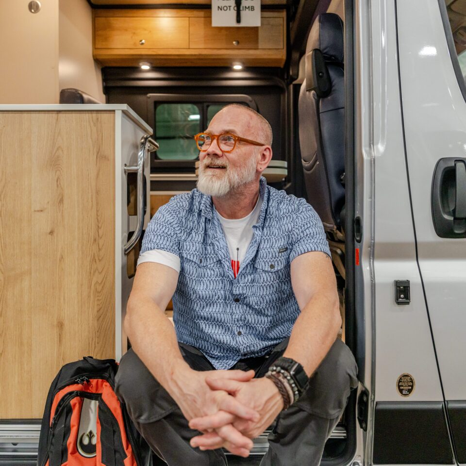 Man sitting at the entrance of his Class B motorhome
