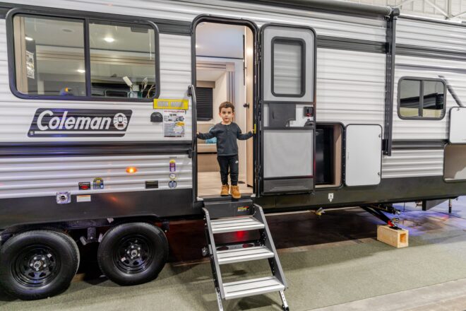 Child exiting a travel trailer RV at an RV Show