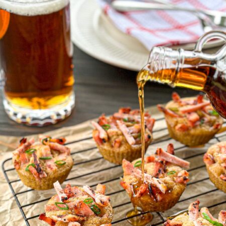 Mini pancakes on a cooling rack with a pint of beer and maple syrup