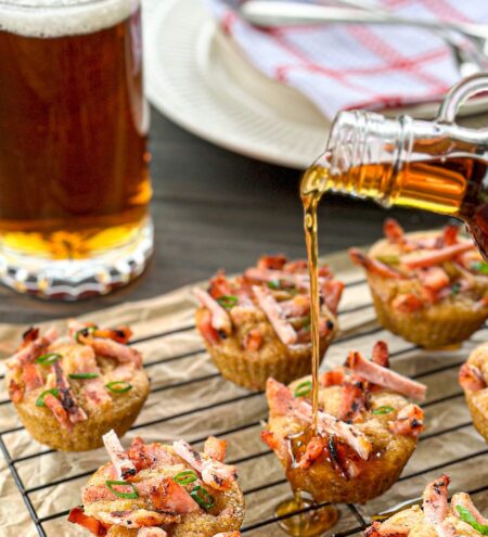 Mini pancakes on a cooling rack with a pint of beer and maple syrup