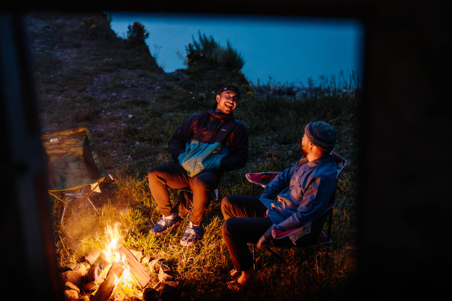 two friends sitting by their campfire camping in their motorhome in Abraham Lake