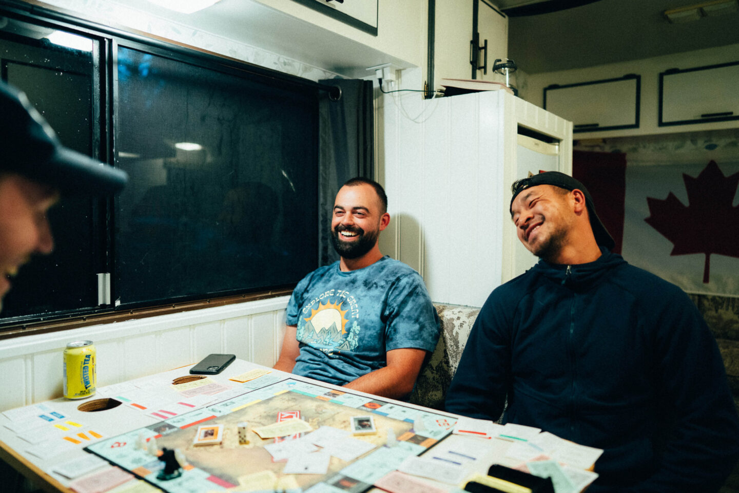 Friends playing monopoly inside their campervan, class b motorhome