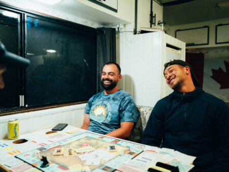 Friends playing monopoly inside their campervan, class b motorhome
