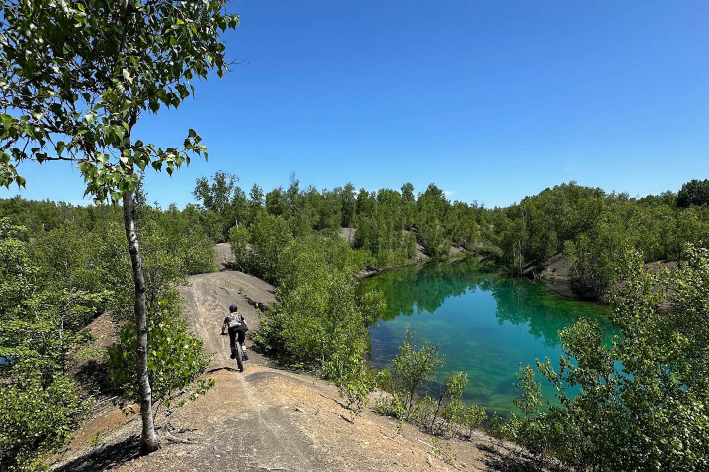 Person mountain biking in Minto New Brunswick, Minto MTB