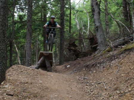 Mountain biker going off of a jump in Wentworth Mountain Bike Park, Nova Scotia