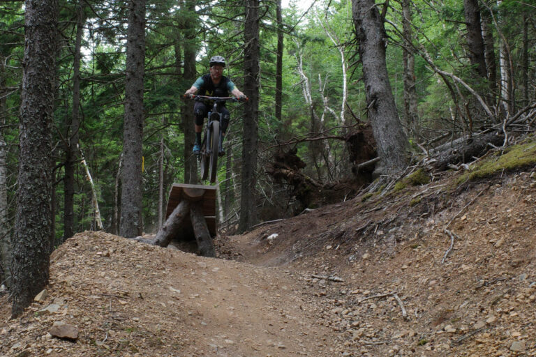 Mountain biker going off of a jump in Wentworth Mountain Bike Park, Nova Scotia