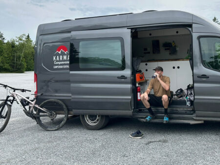 Man resting in his Class B Camper Van after a mountain biking trail ride at Rockwood Park New Brunswick