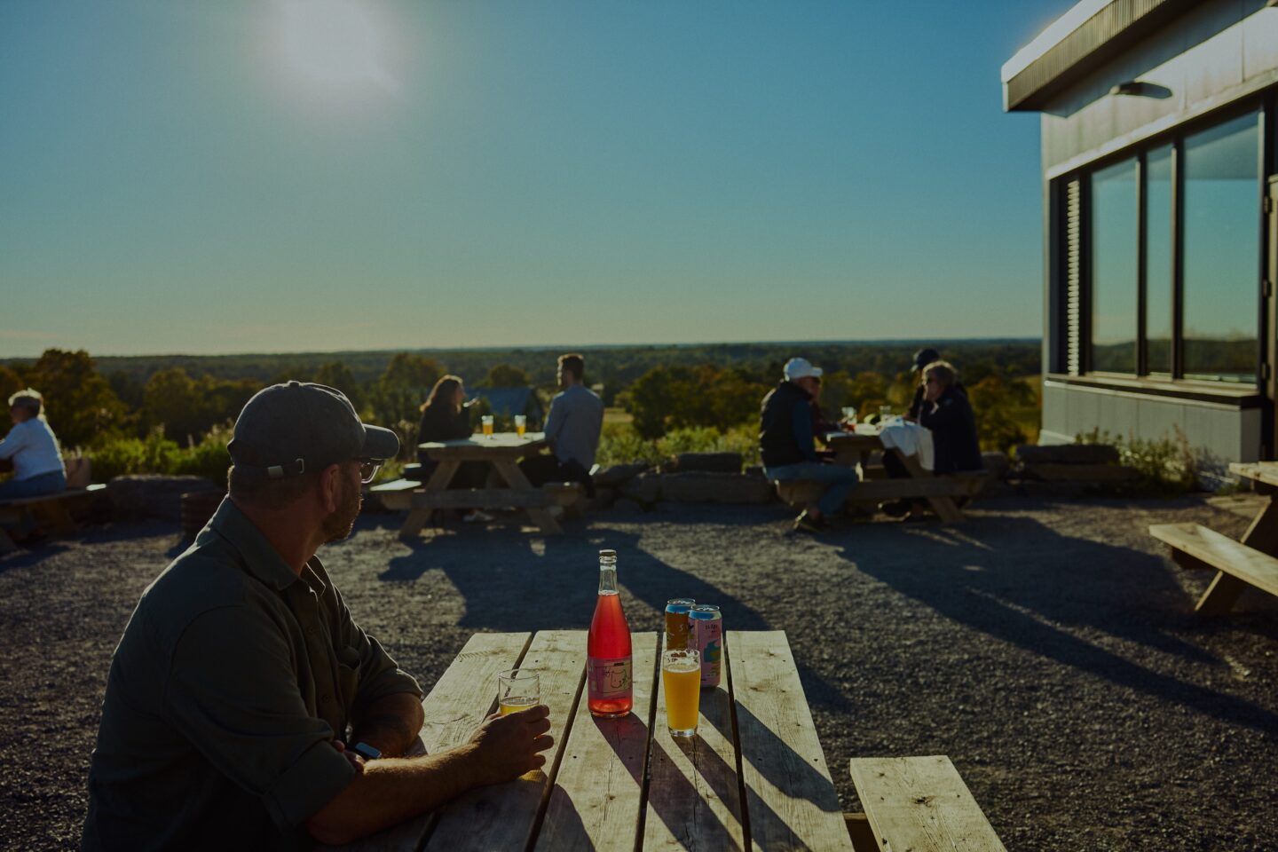 Can of craft beer on the outdoor patio overlooking farm fields at Slake Brewing in Prince Edward County