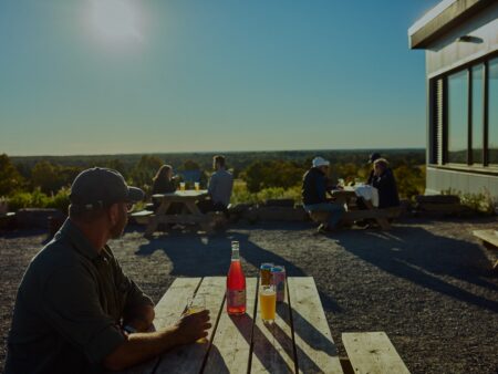 Can of craft beer on the outdoor patio overlooking farm fields at Slake Brewing in Prince Edward County