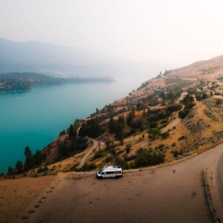 Class B camper van parked overlooking turquoise waters on Kalamalka Lake on a Vernon to Revelstoke RV road trip