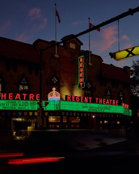 Glowing marquee sign of the historic Regent Theatre at night on Main Street in downtown Picton Ontario