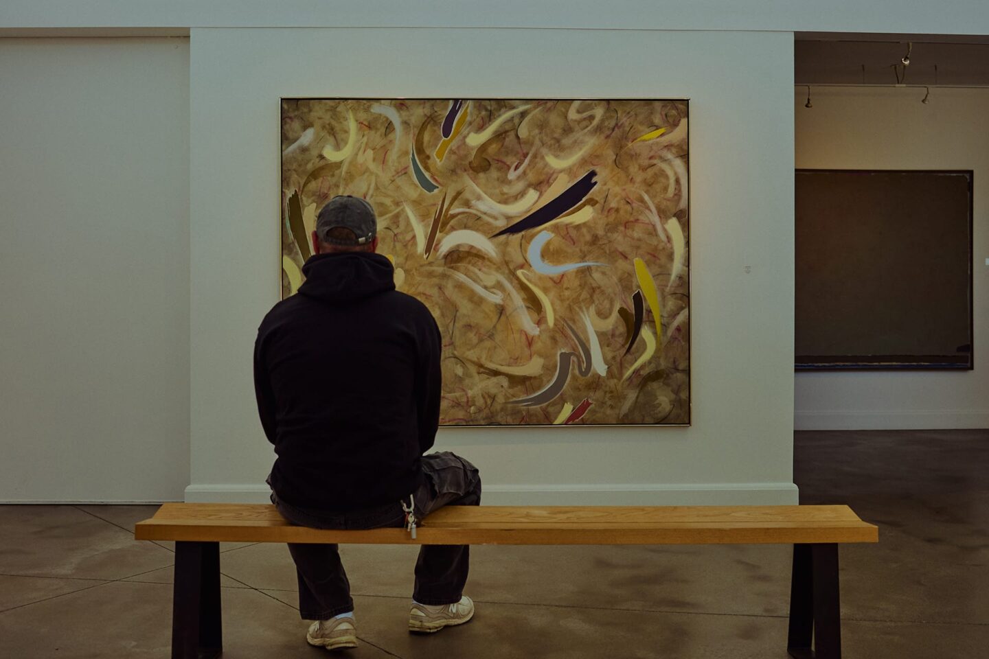 Visitor viewing contemporary Canadian paintings inside the indoor exhibition room at Oeno Gallery in Bloomfield