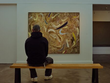 Visitor viewing contemporary Canadian paintings inside the indoor exhibition room at Oeno Gallery in Bloomfield
