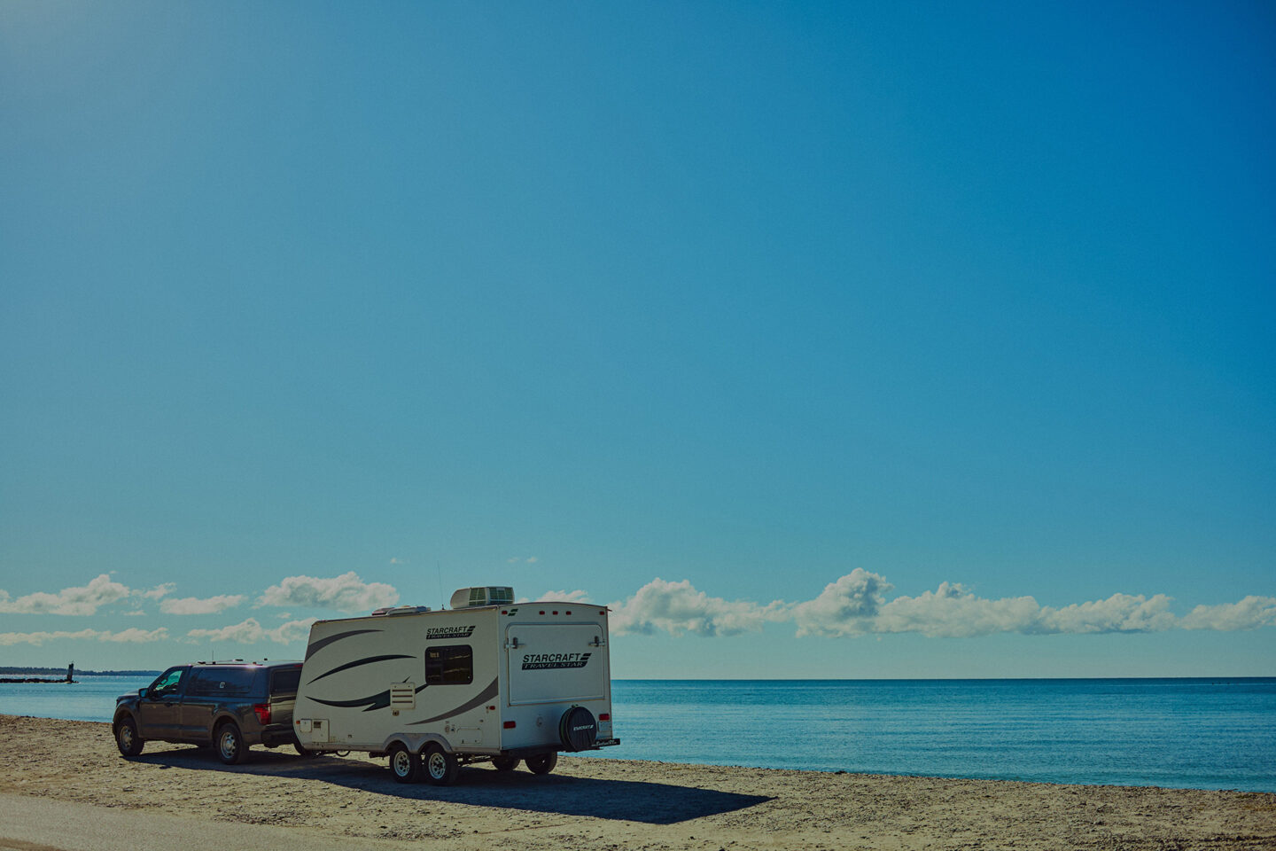 Travel trailer RV parked near the sand dunes at Sandbanks Provincial Park during a Prince Edward County RV road trip